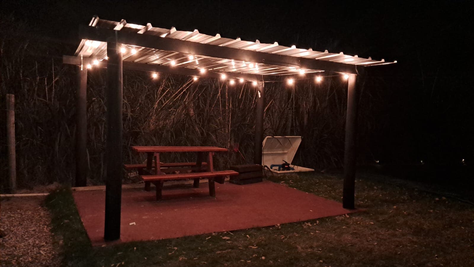 Quincho con mesa de madera y guirnalda de luces